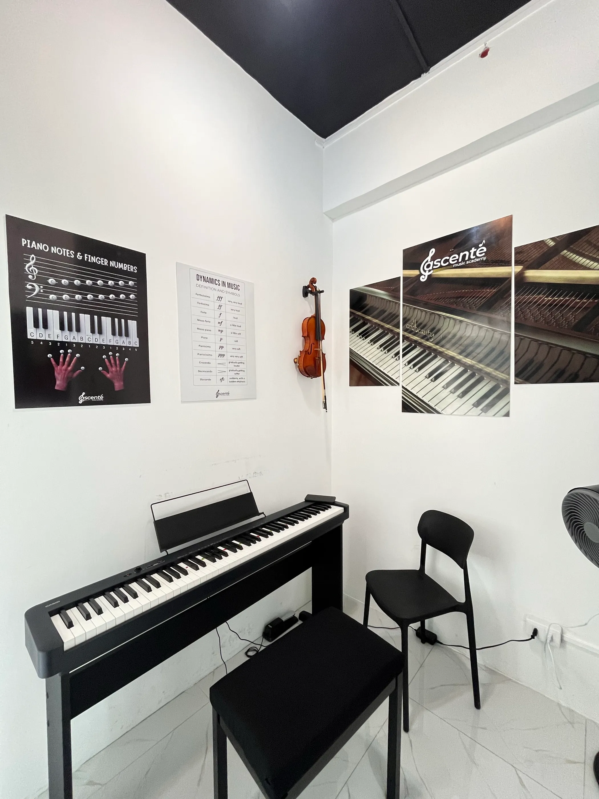 The piano studio at Ascente Music Academy, with a digital piano and a violin on the wall